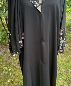 Abaya noire longue et fluide ornée de magnifiques détails floraux multicolores au col et aux manches. Une pièce élégante et féminine, idéale pour les sorties et les occasions spéciales.