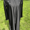 Abaya noire longue et fluide sublimée par d’élégants détails perlés argentés aux épaules et aux manches. Une pièce raffinée idéale pour les fêtes, soirées et occasions spéciales.