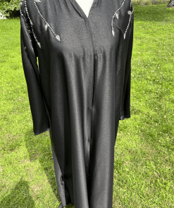 Abaya noire longue et fluide sublimée par d’élégants détails perlés argentés aux épaules et aux manches. Une pièce raffinée idéale pour les fêtes, soirées et occasions spéciales.